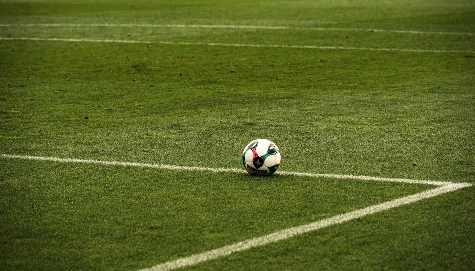 Soccer ball on an empty green football field